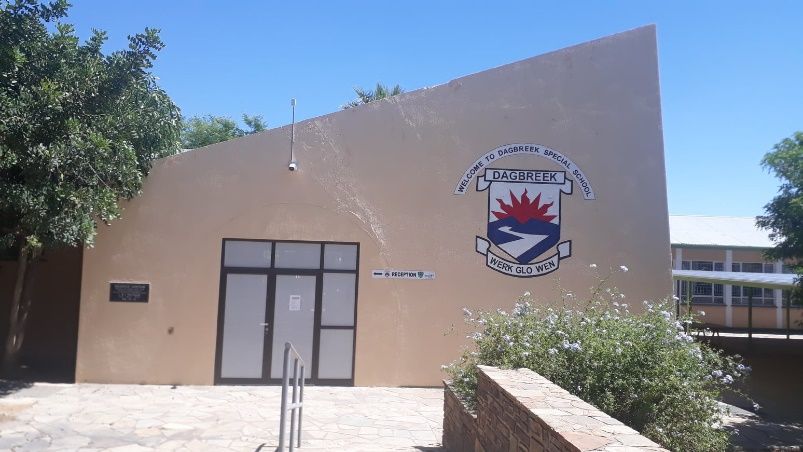 Gebäude der Dagbreek School in Windhoek mit dem Schulwappen an der Fassade