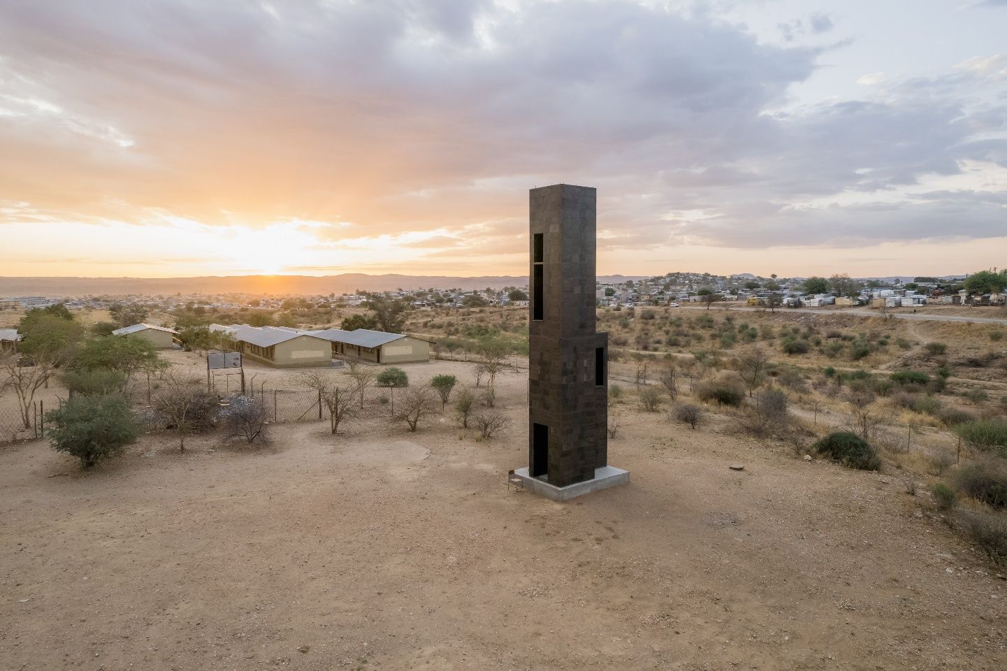 Der schmale Material-Test-Turm steht allein in der Savannenlandschaft bei Sonnenuntergang